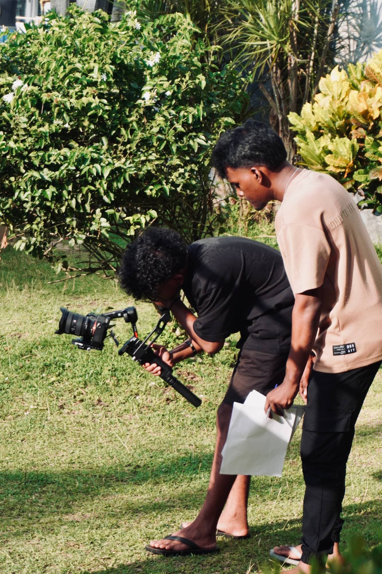 Operator lining up a low shot on the gimbal while direction is given over his shoulder.