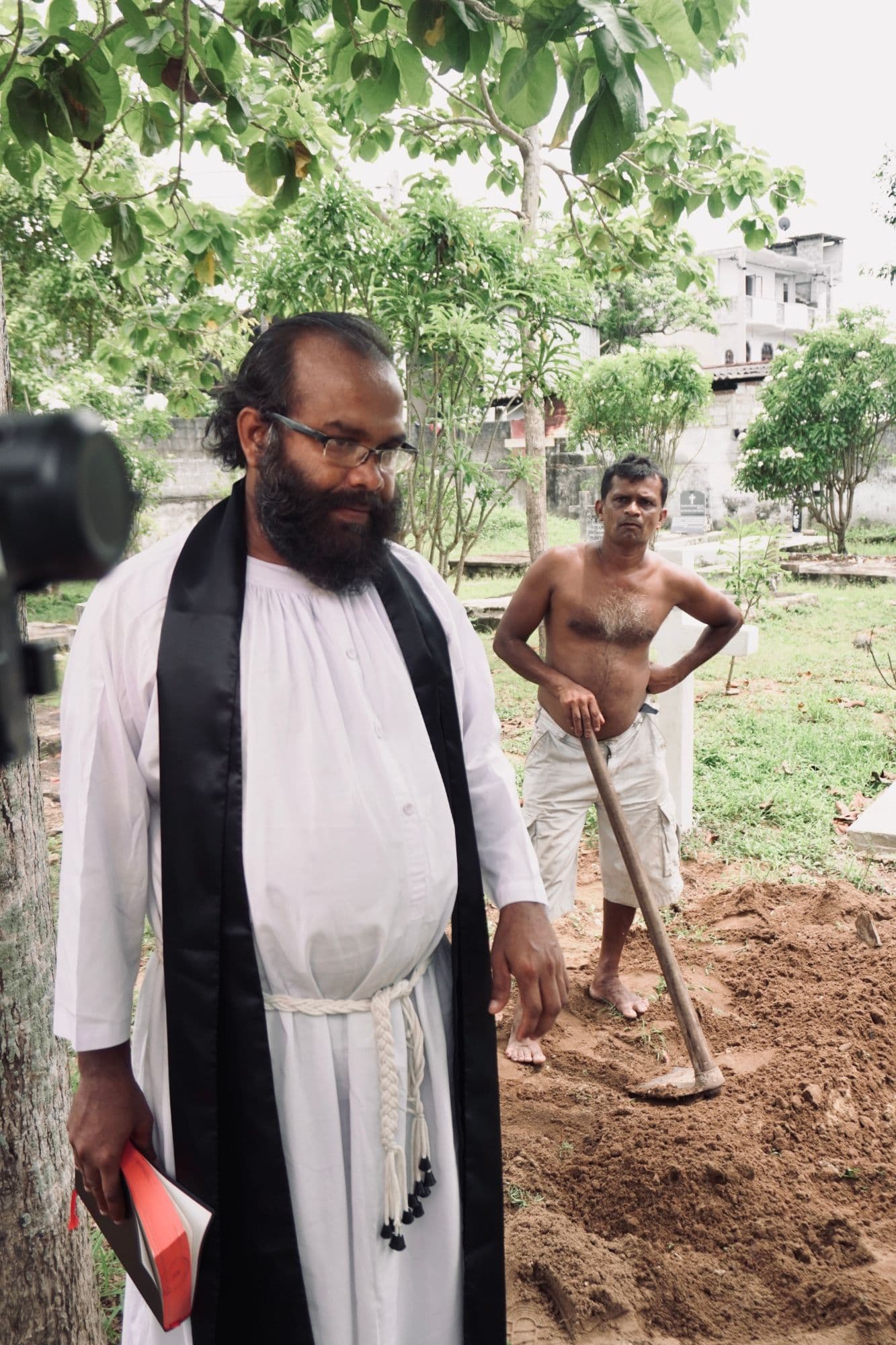 The priest and the gravedigger in position, the grave dug and waiting.