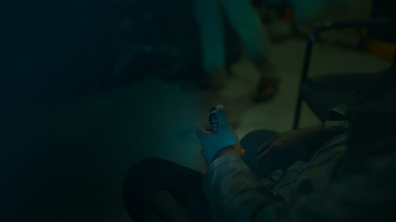 A revolver drawn low, the room falling away into teal shadow.
